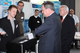Der Bayerische Staatsminister Dr. Wolfgang Heubisch (vorn) und FAU-Präsident Prof. Dr. Karl-Dieter Grüske (rechts) im Gespräch mit Dipl.-Phys. Sebastian Schmitt (Max Planck Institut für die Physik des Lichts) Forscher des Exzellenzclusters.