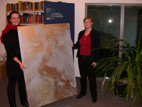 Katrin Sergejew (links) übergab im Dezember letzten Jahres das erste Bild der Reihe an Doktorandin Andrea Steinbrück aus der Abteilung Nanobiophotonik.
