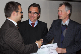 Professor Hartmut Bartelt (rechts), Vorstandsvorsitzender des Beutenbergcampus und Professor Jürgen Popp vom IPHT übergeben den Scheck an PD. Dr. Benjamin Dietzek (links).