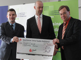 Dr. Wolfgang Paa (r.) nahm im Namen von Christian Karras und in Anwesenheit von Dennys Klein vom Thüringer Ministerium den Diplompreis von Thomas Neupert (Sparkasse Jena) (l.) entgegen.