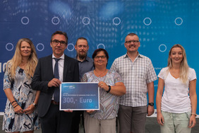 Jürgen Popp überreicht zusammen mit Mitarbeiterinnen und Mitarbeitern des Leibniz-IPHT die Spendensumme an die Geschäftsführerin des Vereins, Katrin Mohrholz (vierte von links).Quelle: IPHT Jena